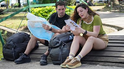 Kelly Brook and her husband Jeremy sit on the ground reading maps