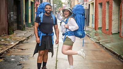 Kola Bokinni and his cousin Mary Ellen stand on a street wearing their backpacks