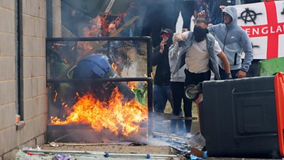 Protestors throwing objects outside a hotel in Rotherham.