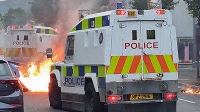 Police van with a fire in the background