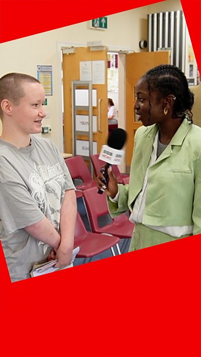 BBC presenter holding mic stands with student talking about results