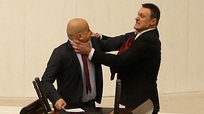 Alpay Ozalan with hands around Ahmet Sik's neck during brawl