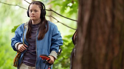 Bethany Asher as Stephie Bottomley in a forest with earphones on