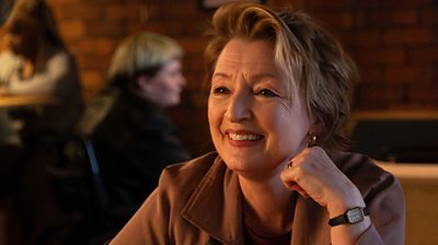 Lesley Manville as Julie Jackson smiling at something offscreen