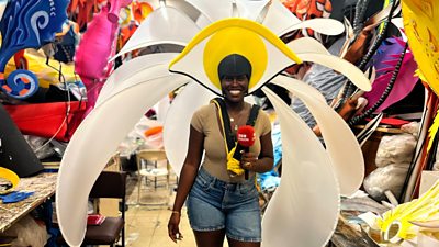 Aminata Kamara smiles at the camera whilst wearing a flowery carnival costume