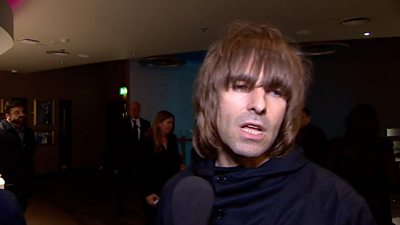 Liam Gallagher talks into a microphone