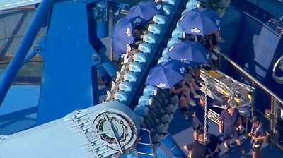 People on a ride covered under umbrellas