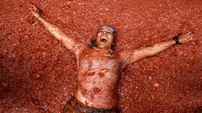 Woman bathing in tomato during La Tomatina Festival