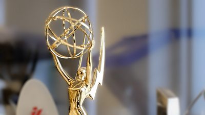 Emmy award - a gold statuette of a winged figure holding a globe or atom