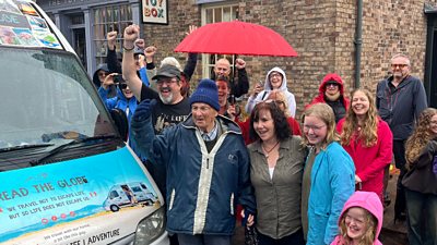 Group of five people stood by camper van