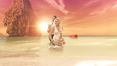 Key art for Stranded on Honeymoon Island: a bride and groom wade through the water on a sandy beach. The sun sets on the horizon behind them. A red box floats out on the water in the distance. 
