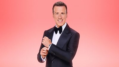 Anton Du Beke wears a dark tuxedo and bow tie and smiles for the camera, adjusting his cuff.