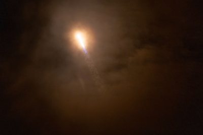 A rocket rising into the dark sky