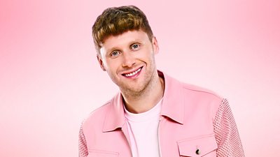 Jamie Borthwick smiles to the camera wearing a pink shirt jacket over a pink t-shirt