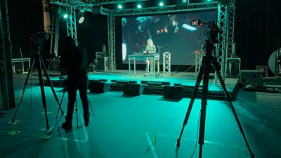 Music artist TWST performing on the stage viewed from the lighting desk.