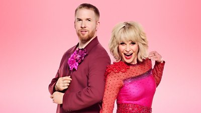 Neil and Toyah stand back to back wearing red outfits