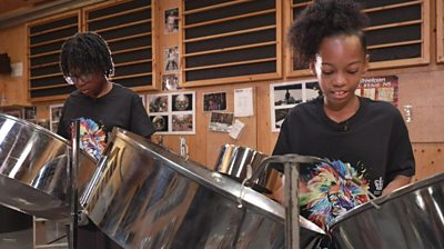 steelpan players in a rehearsal space