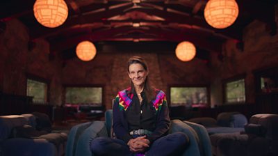 Aileen Getty sitting on a chair with her legs crossed and facing the camera