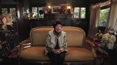 Margaret O’Brien sitting on a sofa in a living room with bunches of flowers everywhere