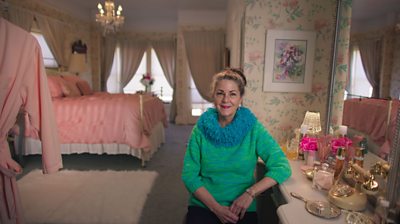 Jorjett Strumme leaning on a dresing table in a floral and pink room