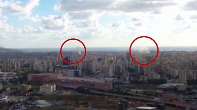 View of Beirut skyline, where two circles are outlining smoke appearing to come out of explosions across the city