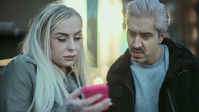 image of a woman holding a phone and showing it to  Mobeen Azhar 