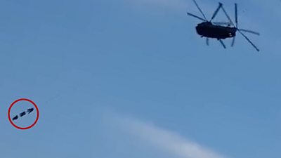 Soldiers dangle below chinook helicopter