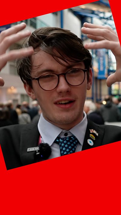 A young, male, Tory activist. He's wearing glasses and waving his hands