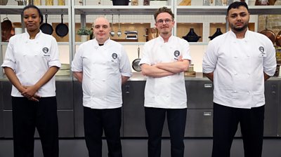 Four MasterChef contestants Paule, Dan, Ritchie and Alin stand smiling in the MasterChef kitchen wearing MasterChef branded shirts