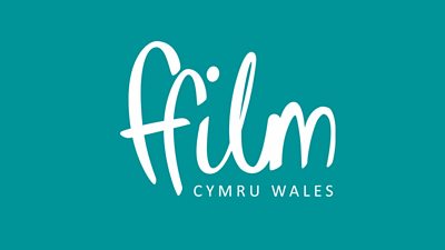 The text ffilm cymru wales in white on a solid teal coloured background