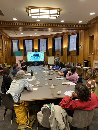 ý Writers Scripted 2024/25 development group in the Council Chamber at ý Broadcasting House in London.