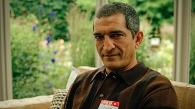  Omar (Amr Waked) looking straight to camera. He's wearing a sticker with his name on it