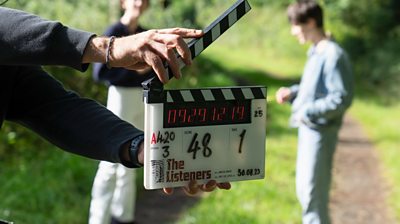 behind the scenes shot showing a clapperboard in front of a blurry Claire (Rebecca Hall) and Kyle (Ollie West)