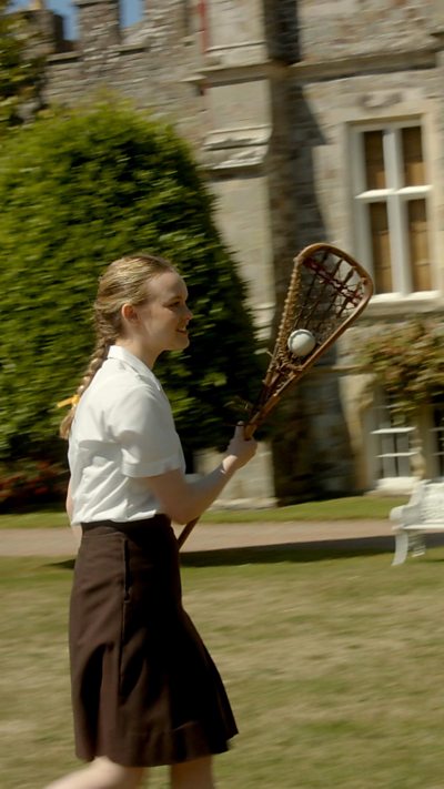A girl playing lacrosse.