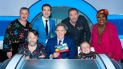 Left to right: Laura Smyth, David Mitchell, Jimmy Carr, Rob Brydon, Lee Mack, Lenny Rush and Rustie Lee behind Rob Brydon's desk