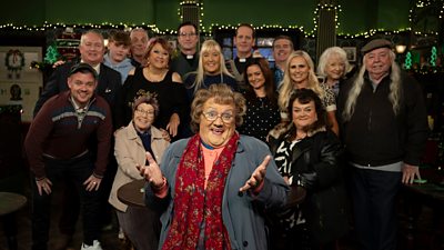 The cast of Mrs Brown's Boys gather around Mrs Brown in the pub