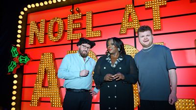 John Kearns, Judi Love and Dan Tiernan stand in front a brightly lit sign that reads Noël at the Apollo