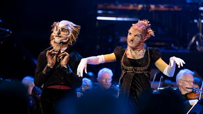 A pair of people dressed as Chuldurs (bird-headed creatures) pose amid musicians at The Proms