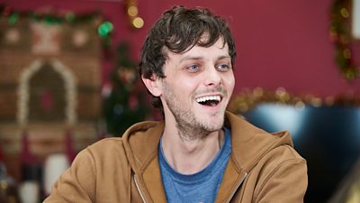 Close-up of a man laughing as he looks at something offscreen. 