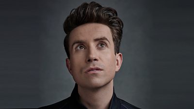 A headshot of Nick Grimshaw, pictured against a dark grey background. Nick's eyes look up to the sky.