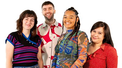 Four young people stand smiling in a group