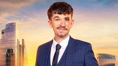 Jonny wears a blue chequered suit and waistcoat with a navy tie and white shirt. He smiles at the camera. A backdrop of the London skyline at sunset 