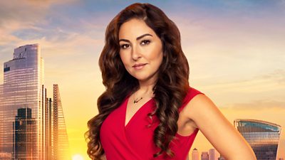 Melica wears a sleeveless red dress with a gold necklace. She stands with hands on hips and her long curled brown hair drapes over each shoulder. A backdrop of the London skyline at sunset 