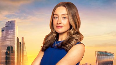 Mia wears a blue sleeveless dress and silver necklace. She stands with arms crossed and her mid length hair rests on her shoulders. A backdrop of the London skyline at sunset 