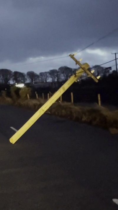 A telegraph pole leaning in a country road