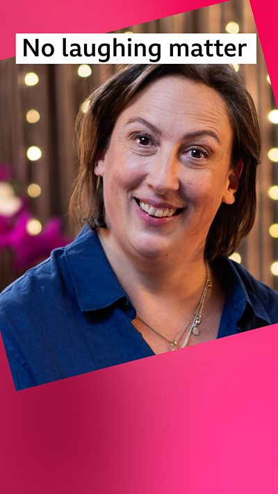 A woman, Miranda Hart, wears a blue shirt and smiles at the camera