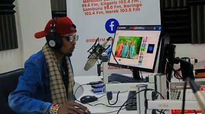 Wambaz presenting his radio show on Sidai FM in Narok County