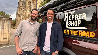  Dominic Chinea and Will Kirk in front of a van with an ecclesiastical building behind