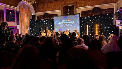 Speakers on a stand in front of an audience