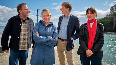 Lee Mack, Sally Bretton, Kris Marshall and Zahra Ahmadi stood together on a jetty wearing outdoor jackets and red noses